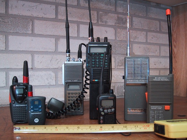 Several handheld walkie-talkies of different makes standing side by side, for storm prep in Panama City, FL
